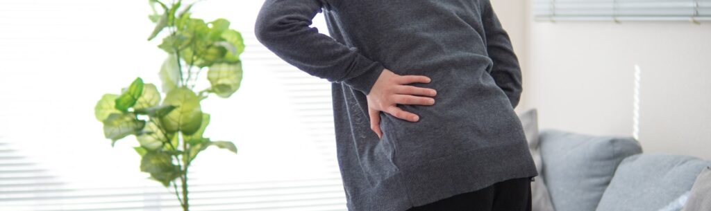 腰痛の症状が重く辛そうな女性